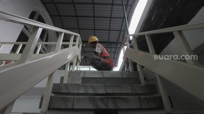 Pekerja menyelesaikan perbaikan Masjid Cut Meutia, Jakarta, Kamis (25/3/2021). [Suara.com/Angga Budhiyanto]