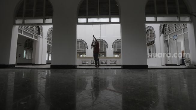 Pekerja menyelesaikan perbaikan Masjid Cut Meutia, Jakarta, Kamis (25/3/2021). [Suara.com/Angga Budhiyanto]