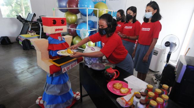 Seorang siswi menata makanan yang akan diantar dengan "autobot waiters robot" di Lembaga Kursus dan Pelatihan (LKP) Autobot School, Klaten, Jawa Tengah, (25/3/2021).  ANTARA FOTO/Aloysius Jarot Nugroho