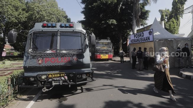 Mobil anti huru-hara milik polisi terparkir saat berlangsungnya sidang lanjutan kasus pelanggaran protokol kesehatan dengan terdakwa Rizieq Shihab di depan Pengadilan Negeri (PN) Jakarta Timur, Jakarta, Jumat (26/3/2021). [Suara.com/Angga Budhiyanto]