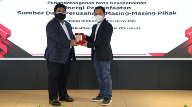 Direktur Enterprise & Business Service Telkom Edi Witjara (kanan) menyerahkan cindera mata kepada Direktur Pengembangan Sumber Daya BKI, Saifudin Wijaya, Jakarta, Rabu (24/3/2021). (Dok : Telkom