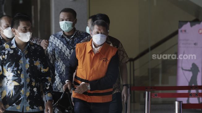 Mantan Direktur Utama PT Pelindo II (Persero) Richard Joost Lino (kanan) mengenakan rompi tahanan usai diperiksa di gedung KPK, Jakarta, Jumat (26/3/2021). [Suara.com/Angga Budhiyanto]