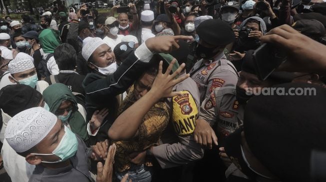 Massa pendukung Rizieq Shihab melakukan demonstrasi saat berlangsungnya sidang lanjutan kasus pelanggaran protokol kesehatan dengan terdakwa Rizieq Shihab di depan Pengadilan Negeri (PN) Jakarta Timur, Jakarta, Jumat (26/3/2021). [Suara.com/Angga Budhiyanto]