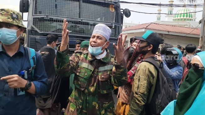 Pria berbaju loreng marah karena polisi bubarkan pendukung Rizieq saat berselawat di luar PN Jaktim. (Suara.com/Yaumal)