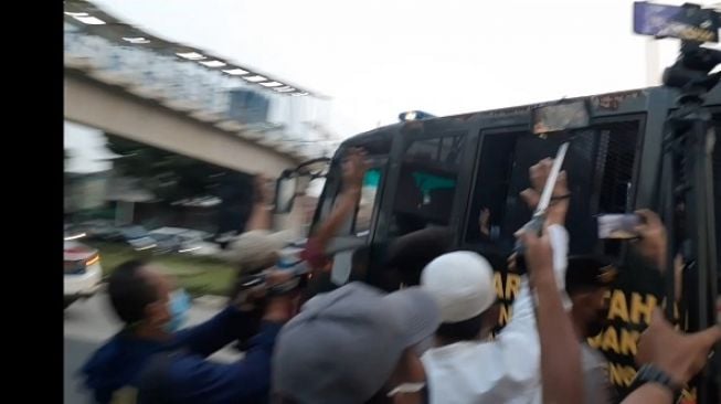 Penampakan Habib Rizieq saat dibawa menggunakan mobil tahanan Kejaksaan usai menjalani sidang sejumlah kasus di PN Jakarta Timur. (Suara.com/Yaumal)