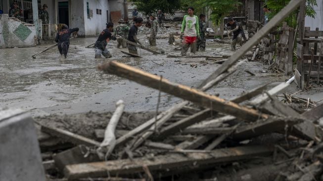 Sejumlah relawan dan anggota TNI membersihkan sisa lumpur yang menerjang permukiman di Desa Beka, Marawola, Kabupaten Sigi, Sulawesi Tengah, Sabtu (27/3/2021). [ANTARAFOTO/Basri Marzuki]