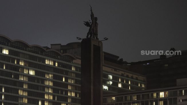 Suasana Bundaran Hotel Indonesia (HI) yang sebagian penerangannya dipadamkan saat berlangsung Earth Hour di Jakarta, Sabtu (27/3/2021). [Suara.com/Angga Budhiyanto]