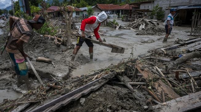 Sejumlah warga membersihkan sisa lumpur yang menerjang rumahnya di Desa Beka, Marawola, Kabupaten Sigi, Sulawesi Tengah, Sabtu (27/3/2021). [ANTARAFOTO/Basri Marzuki]