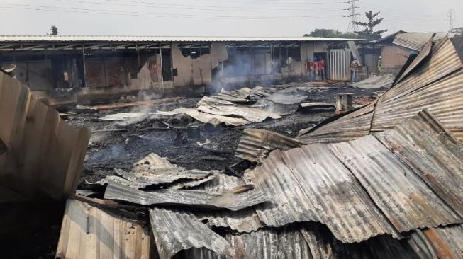 Petugas BPBD Kabupaten Tangerang dan Damkar Kota Tangsel melakukan pendinginan api yang melahap mes pekerja di Desa Sampor, Cisauk, Sabtu (27/3/2021). [Dok, BPBD Kab. Tangerang]