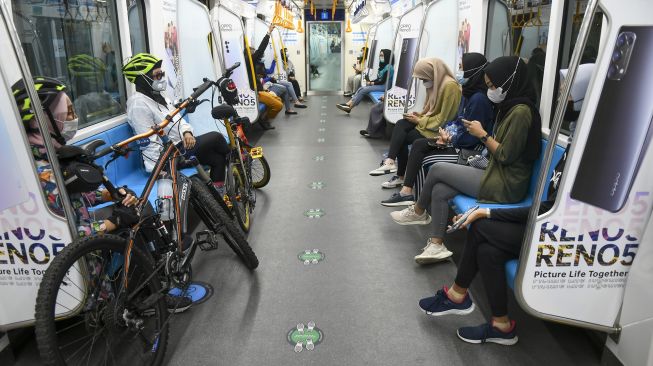 Penumpang membawa sepeda non-lipat di dalam kereta MRT di Jakarta, Minggu (28/3/2021). ANTARA FOTO/Galih Pradipta
