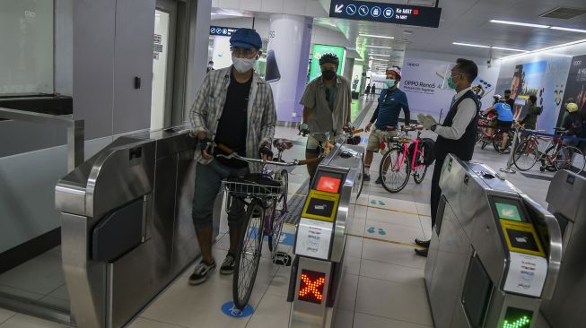 Penumpang membawa sepeda non-lipat di Stasiun MRT Bunderan HI, Jakarta, Minggu (28/3/2021). ANTARA FOTO/Galih Pradipta