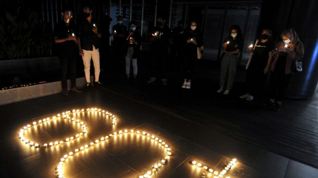 Warga menyalakan lilin membentuk angka 60 plus saat peringatan Earth Hour di Denpasar, Bali, Sabtu (27/3/2021).  ANTARA FOTO/Fikri Yusuf
