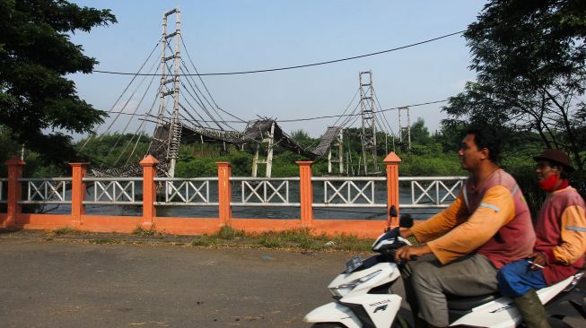 Warga melintas di dekat jembatan bambu di kawasan Ekowisata Mangrove Wonorejo, Surabaya, Jawa Timur, Sabtu (27/3/2021). ANTARA FOTO/Didik Suhartono
