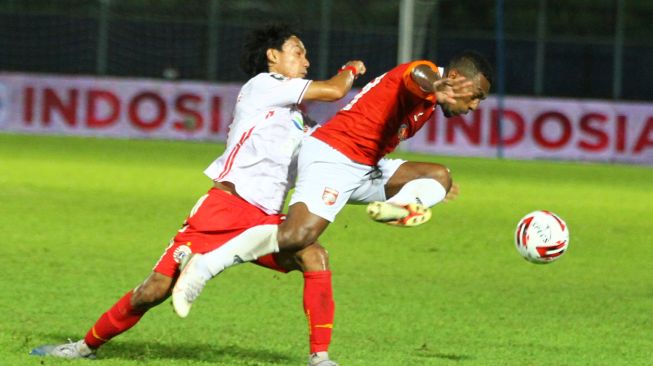 Pesepak bola Persija Jakarta Novri Setiawan (kiri) berusaha menghentikan laju pesepak bola Borneo FC Samarinda, Terens Owang Priska (kanan) dalam pertandingan Piala Menpora Grup B di Stadion Kanjuruhan, Malang, Jawa Timur, Sabtu (27/3/2021). ANTARA FOTO/Ari Bowo Sucipto