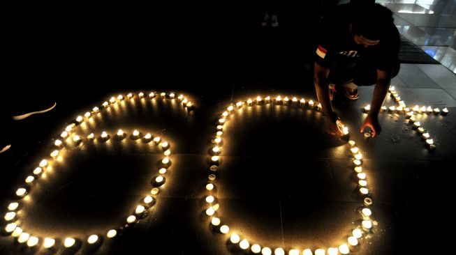 Warga menyalakan lilin membentuk angka 60 plus saat peringatan Earth Hour di Denpasar, Bali, Sabtu (27/3/2021).  ANTARA FOTO/Fikri Yusuf
