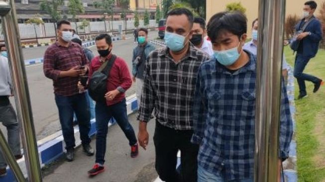 Korban penganiayaan, jurnalis Tempo Nurhadi (baju biru) menuju RS Bhayangkara Surabaya untuk visum. [Suara.com/Dimas Angga P]