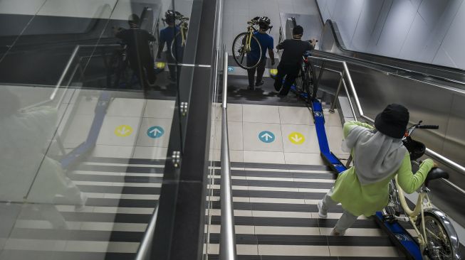 Penumpang membawa sepeda non-lipat di Stasiun MRT Bunderan HI, Jakarta, Minggu (28/3/2021). ANTARA FOTO/Galih Pradipta