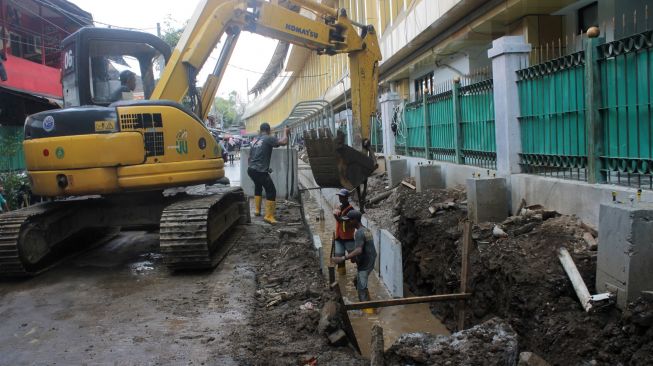 Pekerja menyelesaikan penataan kawasan Stasiun Gondangdia di Jakarta, Senin (29/3).  [Suara.com/Dian Latifah]