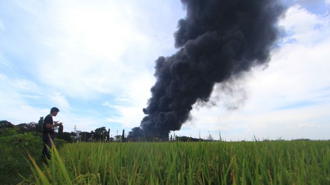 Kepulan asap hitam akibat kebakaran tangki minyak milik Pertamina RU VI Balongan, Indramayu, Jawa Barat, Senin (29/3/2021). ANTARA FOTO/Dedhez Anggara