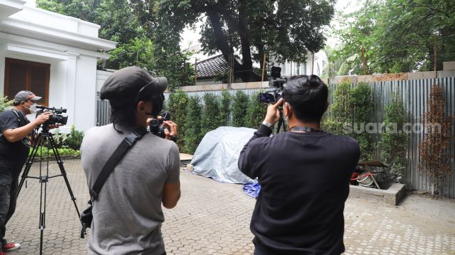 Awak media mengambil gambar tembok sepanjang 5 meter yang sengaja dibangun untuk membagi rumah Hotma Sitompul dengan Desiree Tarigan di Kawasan Cipete, Jakarta Selatan, Senin (29/3/2021). [Suara.com/Alfian Winanto]