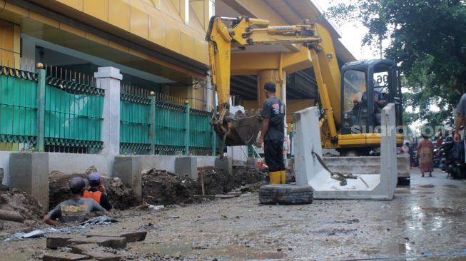 Pekerja menyelesaikan penataan kawasan Stasiun Gondangdia di Jakarta, Senin (29/3).  [Suara.com/Dian Latifah]