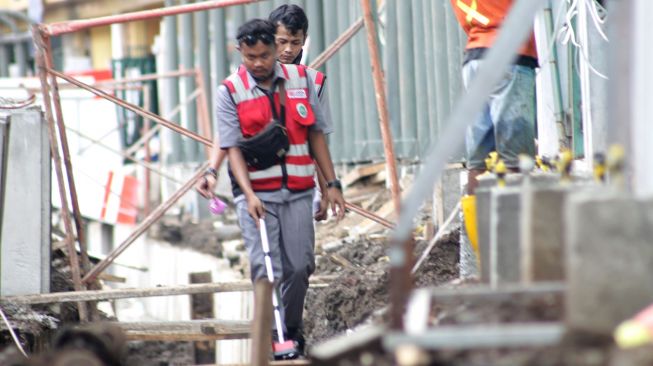 Pekerja menyelesaikan penataan kawasan Stasiun Gondangdia di Jakarta, Senin (29/3).  [Suara.com/Dian Latifah]