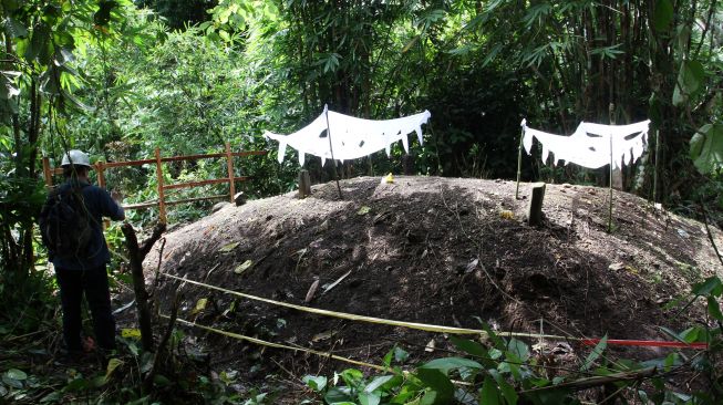 Ahli geologi mengambil foto tumpukan tanah makam yang meninggi di Nagari Sungai Asam, Kecamatan 2 x 11 Enam Lingkung, Padang Pariaman, Sumatera Barat, Senin (29/3/2021). ANTARA FOTO/Muhammad Arif Pribadi