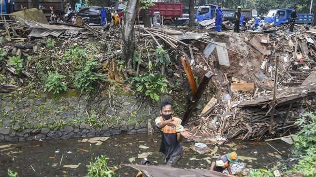 Petugas mengangkat sisa bangunan yang ditertibkan di kawasan Menteng Dalam, Tebet, Jakarta Selatan, Selasa (30/3/2021). ANTARA FOTO/M Risyal Hidayat