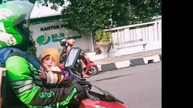 Potret Ojol Kerja Gendong Anak, Barang di Jok Belakang Jadi Sorotan