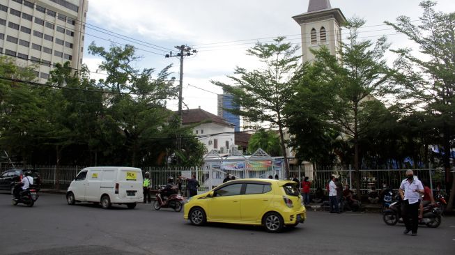 Sejumlah kendaraan melintas di depan Gereja Katedral Makassar, Sulawesi Selatan, Senin (29/3/2021).  ANTARA FOTO/Arnas Padda