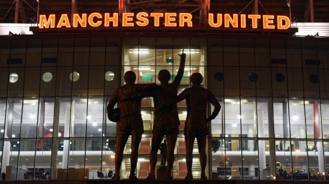 Patung United Trinity di depan Old Trafford. [AFP].