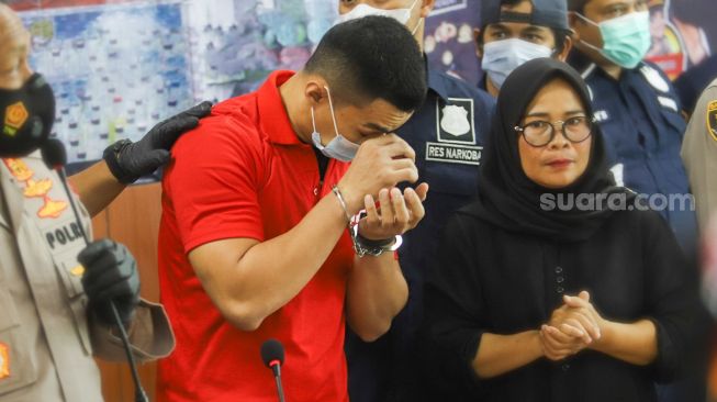 Aktor Agung Saga menghapus air matanya usai memberi pernyataan terkait kasus narkoba yang menjeratnya di Polres Metro Jakarta Pusat, Rabu (31/3/2021). [Suara.com/Alfian Winanto]