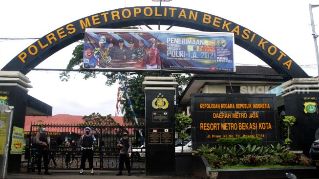 Petugas berjaga di depan pintu gerbang masuk Polres Metro Bekasi Kota, Kota Bekasi, Kamis (01/04/21).  [Suara.com/Dian Latifah]