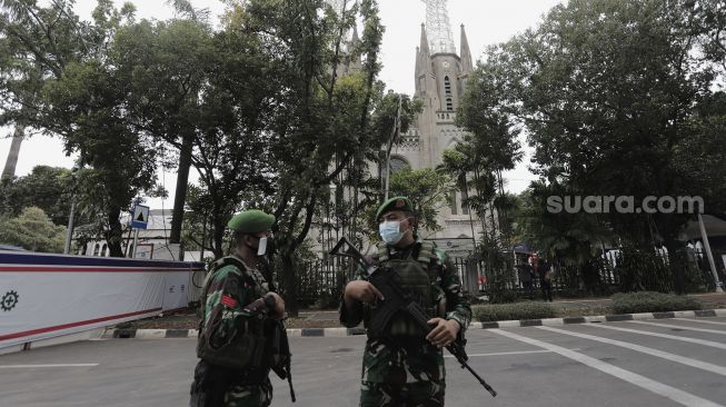 Personel TNI berjaga di depan Gereja Katedral, Jakarta, Kamis (1/4/2021). [Suara.com/Angga Budhiyanto]