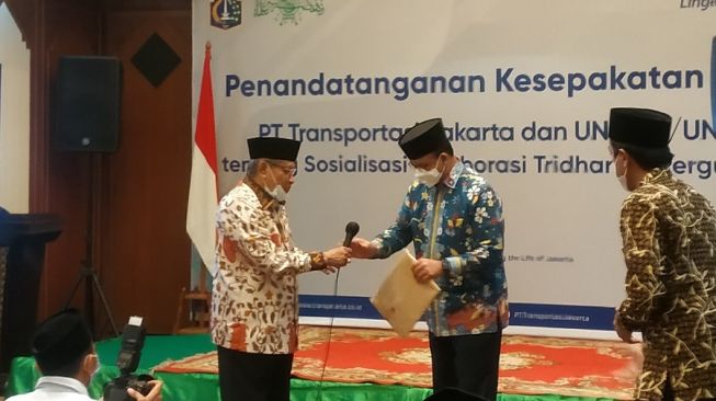 Gubernur DKI Jakarta Anies Baswedan menyerahkan Izin Mendirikan Bangunan atau IMB pesantren milik Ketua Umum Pengurus Besar Nadhlatul Ulama (PBNU) Said Aqil Siradj di gedung PBNU, Jakarta, Kamis (1/4/2021). [Suara.com/Fakhri]