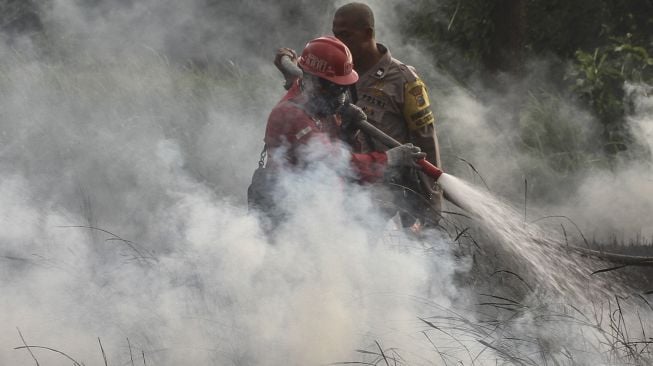 Satgas Kebakaran Hutan dan Lahan (Karhutla) Riau yang terdiri dari petugas Manggala Agni Daops Pekanbaru, BPBD Pekanbaru, Masyarakat Peduli Api dan TNI Polri berusaha memadamkan api yang membakar lahan ketika terjadi kebakaran lahan di Pekanbaru, Riau, Jumat (2/4/2021). [ANTARA FOTO/Rony Muharrman]