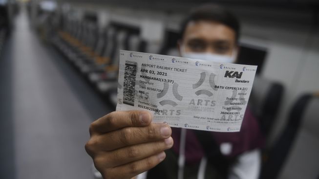 Penumpang menunjukkan tiket kereta bandara premium di Stasiun Manggarai, Jakarta, Sabtu (3/4/2021). [ANTARA FOTO/Akbar Nugroho Gumay]