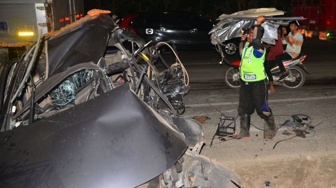 Petugas berusaha mengevakuasi mobil yang ringsek akibat kecelakaan di jalan jalur pantura Desa Bumirejo, Margorejo, Pati, Jawa Tengah, Jumat (2/4/2021).  ANTARA FOTO/Yusuf Nugroho
