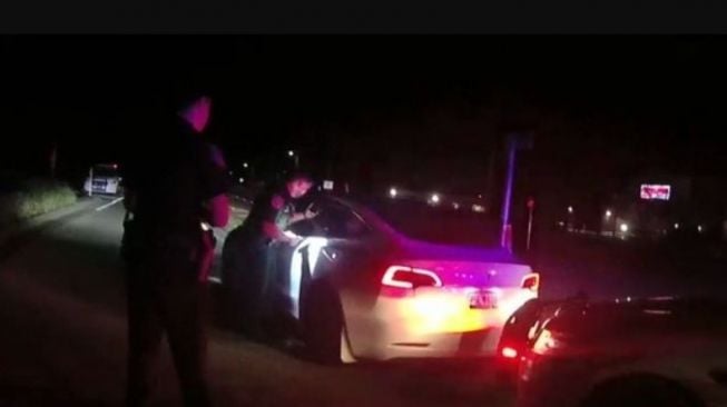 Polisi memberhentikan dua remaja yang tak punya SIM mengendarai mobil Tesla di jalan (Carscoops)