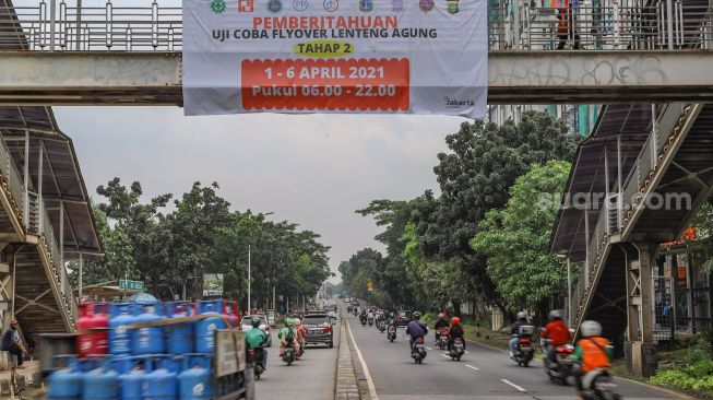 Spanduk berisi infromasi ujicoba Flyover Lenteng Agung di Jakarta Selatan, Minggu (4/4/2021). [Suara.com/Alfian Winanto]