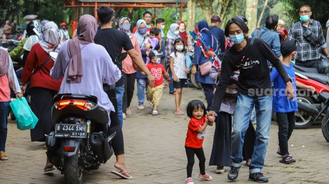 Warga berwisata di Perkampungan Budaya Betawi Setu Babakan, Jakarta Selatan, Minggu (4/4/2021). [Suara.com/Alfian Winanto]