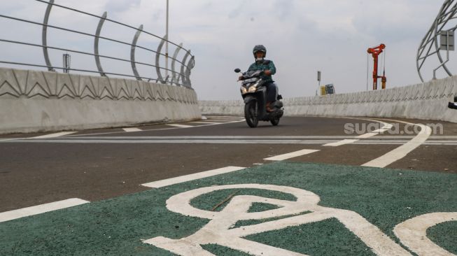 Warga membawa kendaraannya melewati Flyover Lenteng Agung di Jakarta Selatan, Minggu (4/4/2021). [Suara.com/Alfian Winanto]