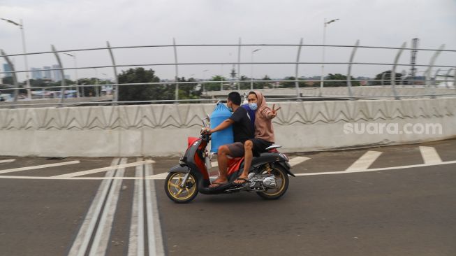 Warga membawa kendaraannya melewati Flyover Lenteng Agung di Jakarta Selatan, Minggu (4/4/2021). [Suara.com/Alfian Winanto]