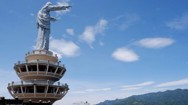 Wisatawan mengunjungi objek wisata religius Patung Tuhan Yesus Memberkati di Buntu Burake, Kabupaten Tana Toraja, Sulawesi Selatan, Sabtu (3/4/2021).  ANTARA FOTO/Spedy Paereng
