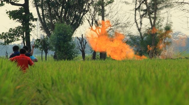 Sejumlah warga mengambil gambar kobaran api dari gas liar di desa Sukaperna, Tukdana, Indramayu, Jawa Barat, Sabtu (3/4/2021). ANTARA FOTO/Dedhez Anggara
