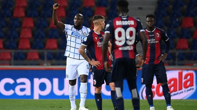 Penyerang Inter Milan Romelu Lukaku melakukan selebrasi setelah mencetak gol pembuka skor selama pertandingan sepak bola Serie A Italia Bologna melawan Inter Milan di Renato Dall'Ara, Minggu (4/4/2021) dini hari WIB. [Vincenzo PINTO / AFP]