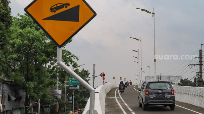 Warga membawa kendaraannya melewati Flyover Lenteng Agung di Jakarta Selatan, Minggu (4/4/2021). [Suara.com/Alfian Winanto]