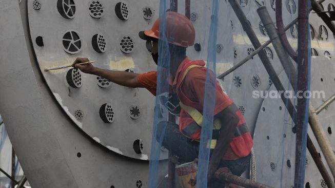 Pekerja menyelesaikan pembangunan Tugu Sepeda di Jalan Jenderal Sudirman, Jakarta, Senin (5/4/2021). [Suara.com/Angga Budhiyanto]