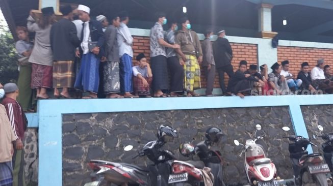 Sejumlah jamaah tengah menunggu proses pemakaman ulama kharismatik Tangerang, KH Uci Thurtusi atau Abuya Uci, di Pondok Pesantren Al-Istiqlaliyyah, Selasa (6/4/2021). [Suara.com/Muhammad Jehan Nurhakim]