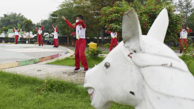 Murid Sekolah Menengah Pertama (SMP) mengikuti pelajaran olahraga saat pembelajaran di luar kelas di Taman Bantaran Sungai Madiun, Kota Madiun, Jawa Timur, Selasa (6/4/2021). [ANTARA FOTO/Siswowidodo]